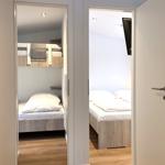 Zwei Schlafzimmer mit jeweils einem Bett und Holzboden