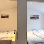 Zwei Schlafzimmer mit Betten und Wandbildern an der Wand.