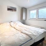 Schlafzimmer mit Bett, Nachttisch und Fenster