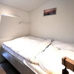 Schlafzimmer mit Bett, Fenster und Wandbild.