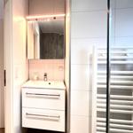 Badezimmer mit Waschbecken, Spiegel und Heizkörper