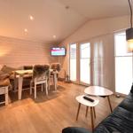 Wohnbereich mit Sofa, Esstisch, TV und Fenster zur Außentür.