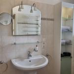 Badezimmer mit Waschbecken, Spiegel und Aufbewahrung