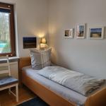 Ein Schlafzimmer mit einem Bett, einem Stuhl und einem Fenster.