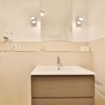 Bad mit Waschbecken, Spiegel und Dusche.