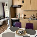 Küche mit Essbereich und Wohnzimmer im Hintergrund.