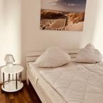 Schlafzimmer mit Bett, Nachttisch und Wandbild