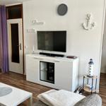 Wohnzimmer mit Fernseher, Sofa und Dekoration an der Wand.