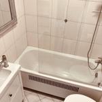 Badezimmer mit Badewanne, Dusche, Waschbecken und Toilette.
