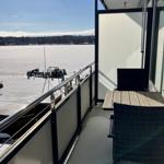 Balkon mit Tisch und Stühlen, Blick auf gefrorenen See.