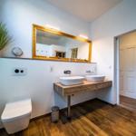 Badezimmer mit Waschtisch, Spiegel und Toilette