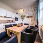 Küche und Essbereich mit Holztisch, Stühlen und Wand mit Punkten.