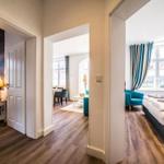 Durchgang zu drei Räumen mit Bett, Sofa und Fenster