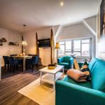 Wohn- und Essbereich mit Sofa, Tisch und Küchenzeile.