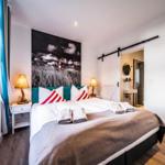 Schlafzimmer mit Bett, Wandbild und Schlafzimmer-Tür.