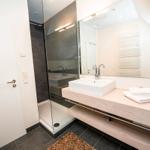 Badezimmer mit Dusche, Waschbecken und Handtuch