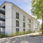 Moderne Wohnanlage mit Balkonen und grüner Umgebung.
