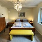 Schlafzimmer mit Doppelbett, Holzmöbel und gelbem Sitzbank.