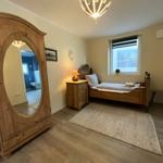 Schlafzimmer mit Holzbett, Kleiderschrank und Fenster