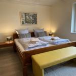 Schlafzimmer mit Doppelbett, Nachttischen und Fenster.