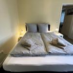 Schlafzimmer mit Doppelbett, zwei Nachttischen und Lampen.