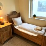 Ein Schlafzimmer mit Holzbett, Nachttisch und Fenster mit Blick auf Wasser.