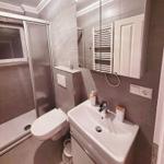 Badezimmer mit Dusche, WC und Waschbecken.