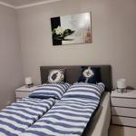 Schlafzimmer mit Doppelbett, zwei Nachttischen und Wandbild.