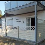 Wohnhaus mit Balkon und weißen Wänden. Sichtbar sind Fenster und Rollladen.