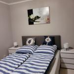 Schlafzimmer mit Doppelbett, zwei Nachttischen und Wandbild.