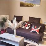 Ein Wohnzimmer mit grauem Sofa, dekorativen Kissen und einem Tisch mit Vasen.