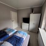 Zimmer mit Doppelbett, Schrank, TV und Fenster mit Blick.