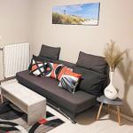 Ein Wohnzimmer mit grauem Sofa, modernem Beistelltisch und Wandbild.