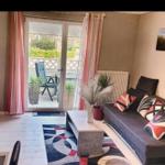 Wohnzimmer mit Sofa, Couchtisch und Balkon. Wandbild und Pflanzen.