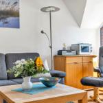 Wohnzimmer mit Sofa, Sessel, Couchtisch und Mikrowelle.