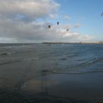 Kitesurfer auf dem Meer unter bewölktem Himmel