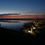 Abendlicher Hafen mit Booten und farbigem Himmel.
