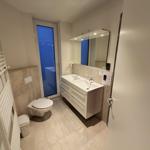 Badezimmer mit Doppelwaschbecken, Toilette und Heizkörper