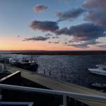 Sonnenuntergang über Hafen mit Booten und modernem Gebäude