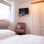 Schlafzimmer mit Bett, Fenster, Kleiderschrank und TV.