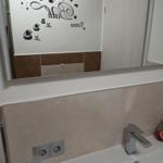 Bathroom with mirror, shower, and sink with faucet