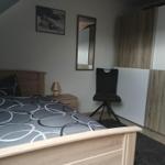 Bedroom with bed, office chair, and wardrobe