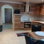 Kitchen with wooden cabinets, stove, and dining area with table and chairs.