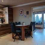Dining area with table and chairs, kitchen, and view of balcony