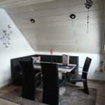 Dining room with bench, table and chairs under sloped ceiling