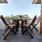 Terrace with wooden table and four chairs, red bouquet on table