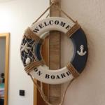 Welcome sign with nautical motif hanging on wall