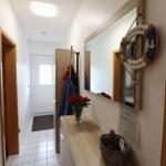 Hallway with mirror, welcome ring, and flowers on console