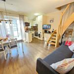 Living area with dining space, kitchen, and staircase.