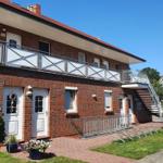 Two-story house with balcony, stairwell, and paved forecourt.